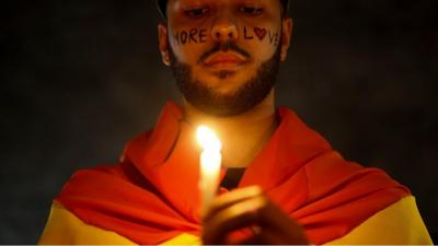 Activist with candle and rainbow flag