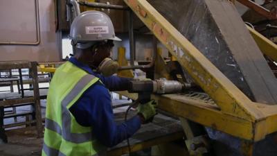 Man in hard hat using a tool