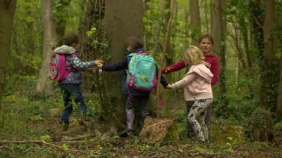 Children playing in woods in Wiltshire