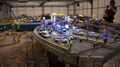 Art display show miniature model of collapsed flyover and emergency services