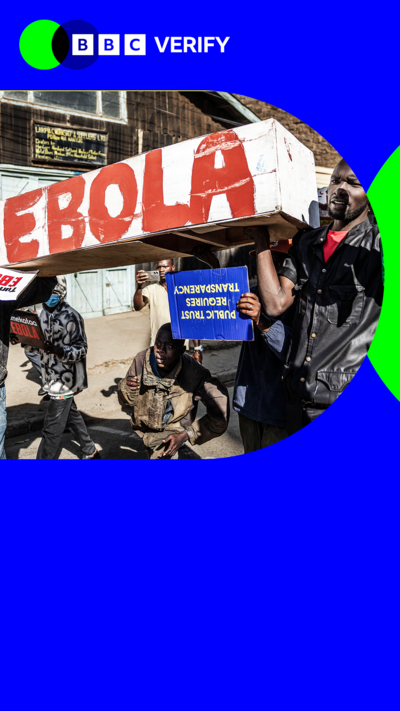 A protest takes place with demonstrators holding a banner. 