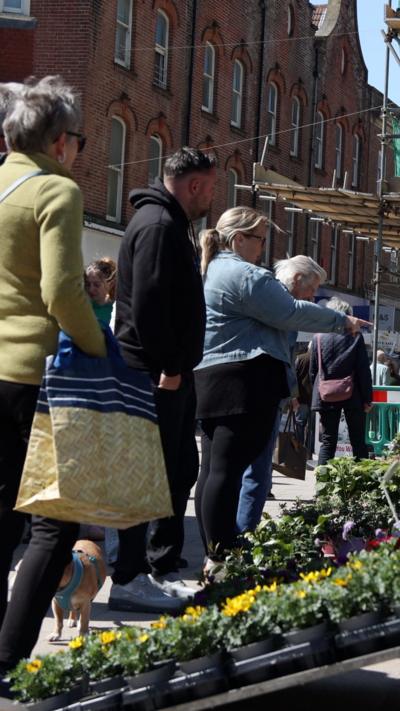 People queue up for a market stool.