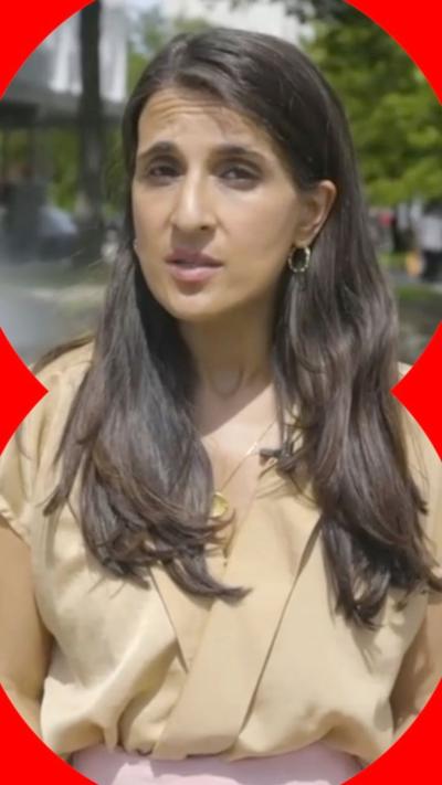 A woman, Nomia Iqbal looking to camera, with long dark hair and a beige top.