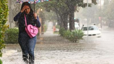 Woman walking on flooded street