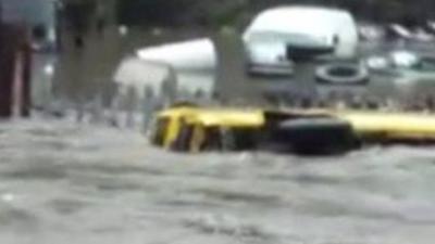 A bus is swept down a flooded street in Hebden