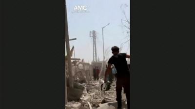 A man stumbles through rubble in Aleppo