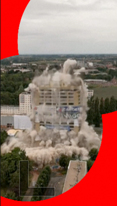 Tower block demolition with dust rising