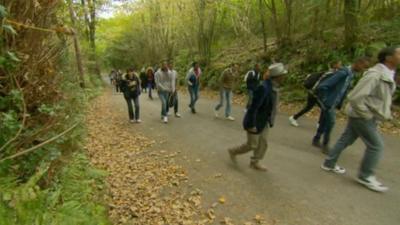 Asylum seekers walk in countryside