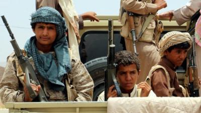 Yemeni fighters ride on a vehicle during an offensive against Houthi rebels positions