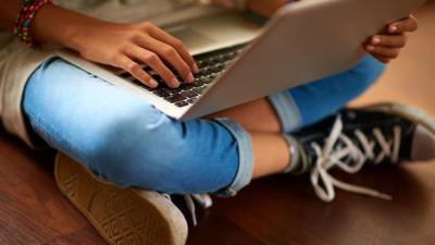 child sat with laptop