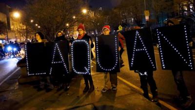 Demonstrators hold signs bearing the name of Laquan McDonald during protests in Chicago, Illinois November 24, 2015