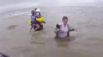 RNLI rescuers with family in water