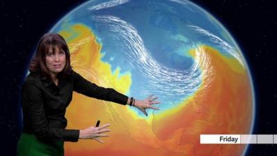 Susan Powell standing in front of a weather map showing all of the US and Canada in blue Arctic air