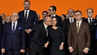 Gordan Grlic-Radman gives Annalena Baerbock a kiss as they pose for a foreign ministers family photo