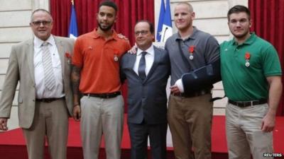 Mr Hollande (C) said of Chris Norman, Anthony Sadler, Spencer Stone and Alek Skarlatos: "You gave us a lesson in courage"