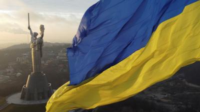 Ukraine's biggest national flag on the country's highest flagpole and the giant Motherland monument are seen at a compound of the World War II museum in Kyiv, Ukraine