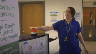 A nurse pressing a buzzer