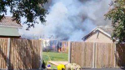 Video shows firefighters tackling flames to the rear of a property and thick plumes of smoke.