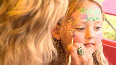 A girl has her face painted