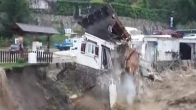 House falling into river