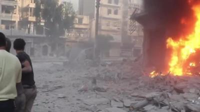 People in Aleppo looking on at a bombed building, Syria