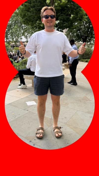 A man wearing shorts, a t-shirt and sandals