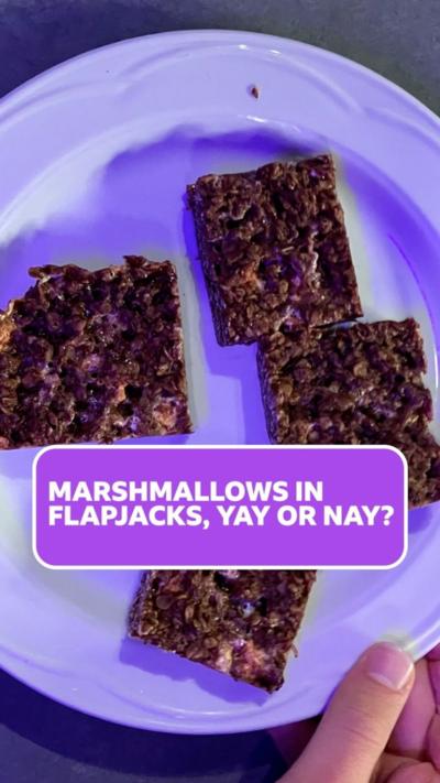 A white plate with four brown chocolate flapjacks on it