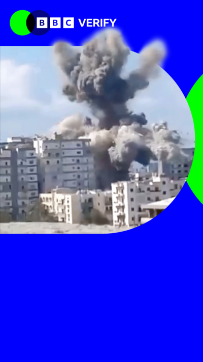 A large smoke plume rising from a high rise building which has just been hit by an air strike