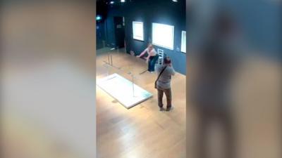 Visitors sit on artwork in Italian museum