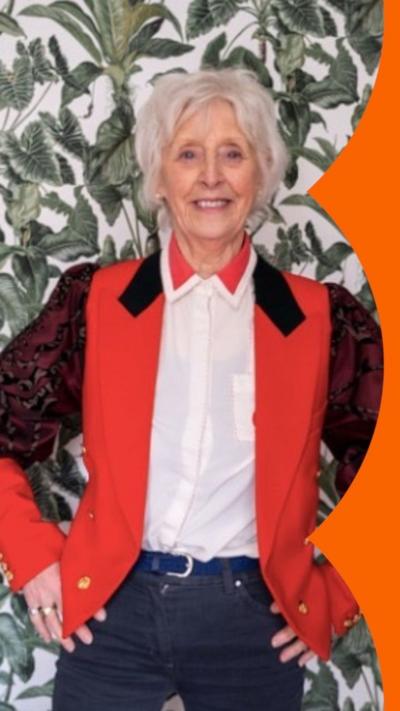 A woman wearing a red coat with a white shirt with a red collar underneath