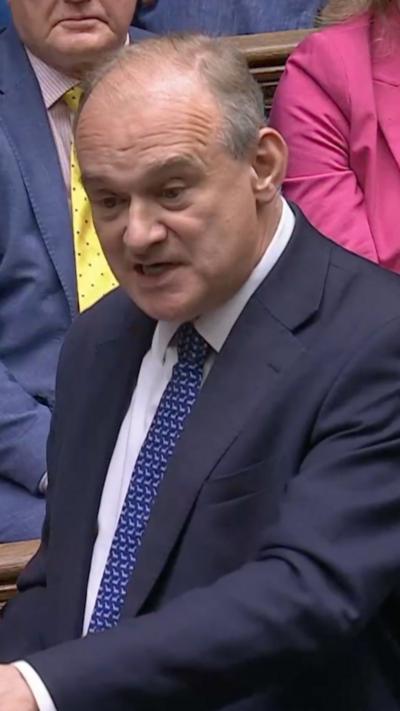 Ed Davey during PMQs wearing navy suit