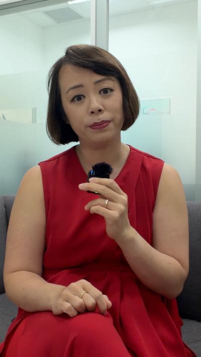 BBC Asia Reporter Tessa Wong wearing read, speaking to a microphone