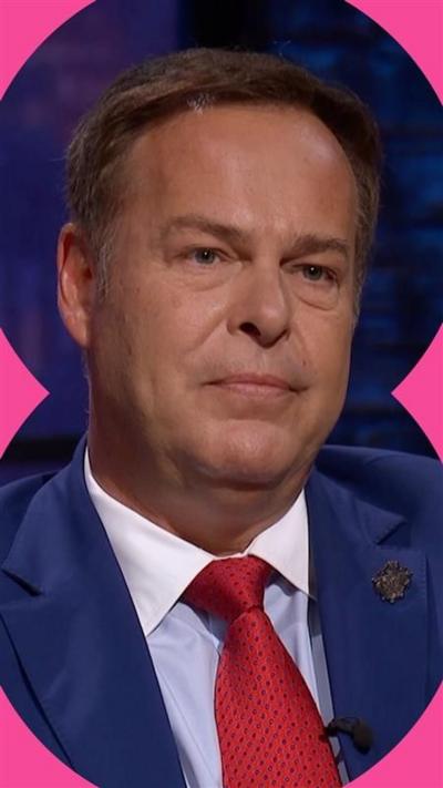 Peter Jones wearing a blue suit and red tie