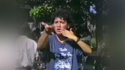 A deaf student using sign language while outdoors