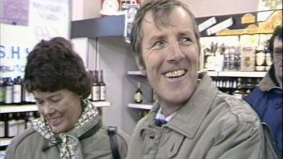 A couple smiling during an interview while buying alcohol