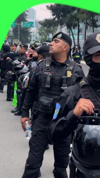 Mexican riot police observe the crowds outside the England football team's hotel