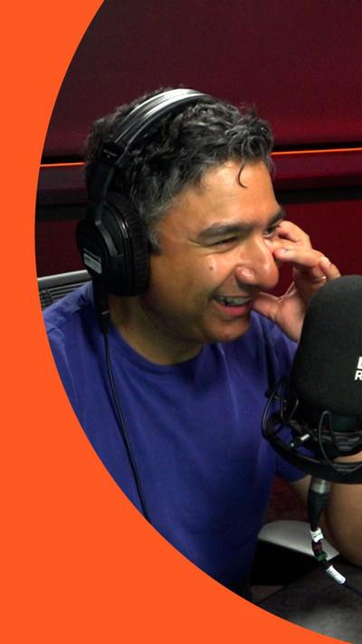 Nick Mohammed smiles in front of a microphone