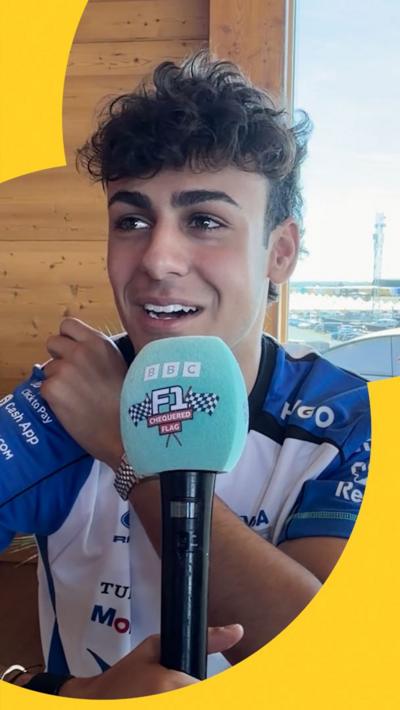 Arvid Lindblad holds up a Chequered Flag Podcast mic
