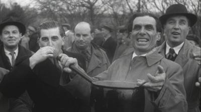 A man holds up a pot of festive food.