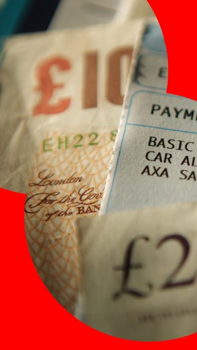A ten pound note and a twenty pound note with a payslip in-between.