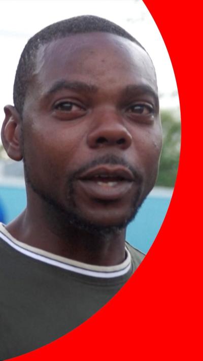 Head shot of man in black t-shirt looking past camera 