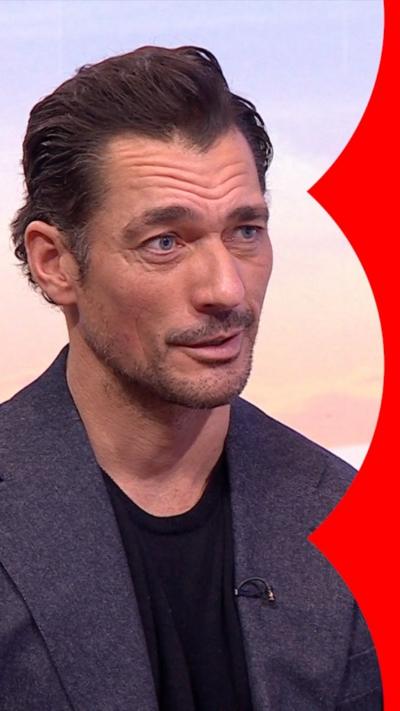 David Gandy speaking, dressed in a black T-shirt and blue jacket