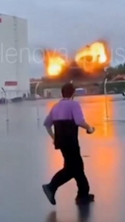 A man is seen in the foreground, behind him is a large explosion