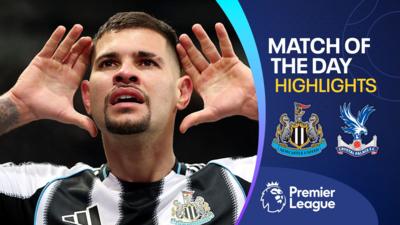 Bruno Guimaraes celebrates with both hands up to his ears in Newcastle kit