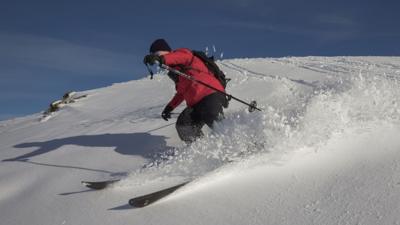 A man skiing in a red jacket