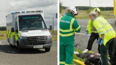 Ambulance drives on road with emergency lights on. Paramedics attend a man lying in a stretcher on the side of a road.