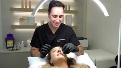 Man giving women lip filler 