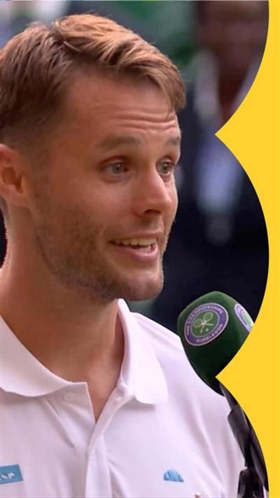 Sem Verbeek speaks into a Wimbledon branded mic - he has short blond hair and wears a white T-shirt
