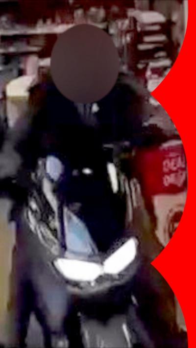 A man wearing black sat on a moped drives out of a Co-op