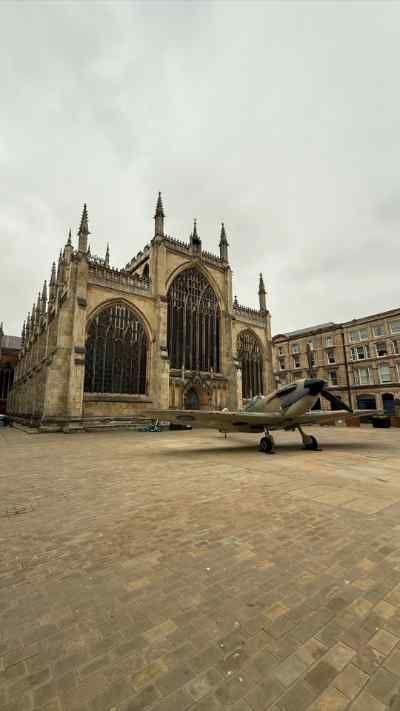 A spitfire on show in Hull in front of a church.